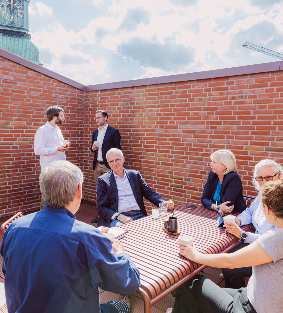 Gruppe an Personen an einen Tisch auf einer Terrasse